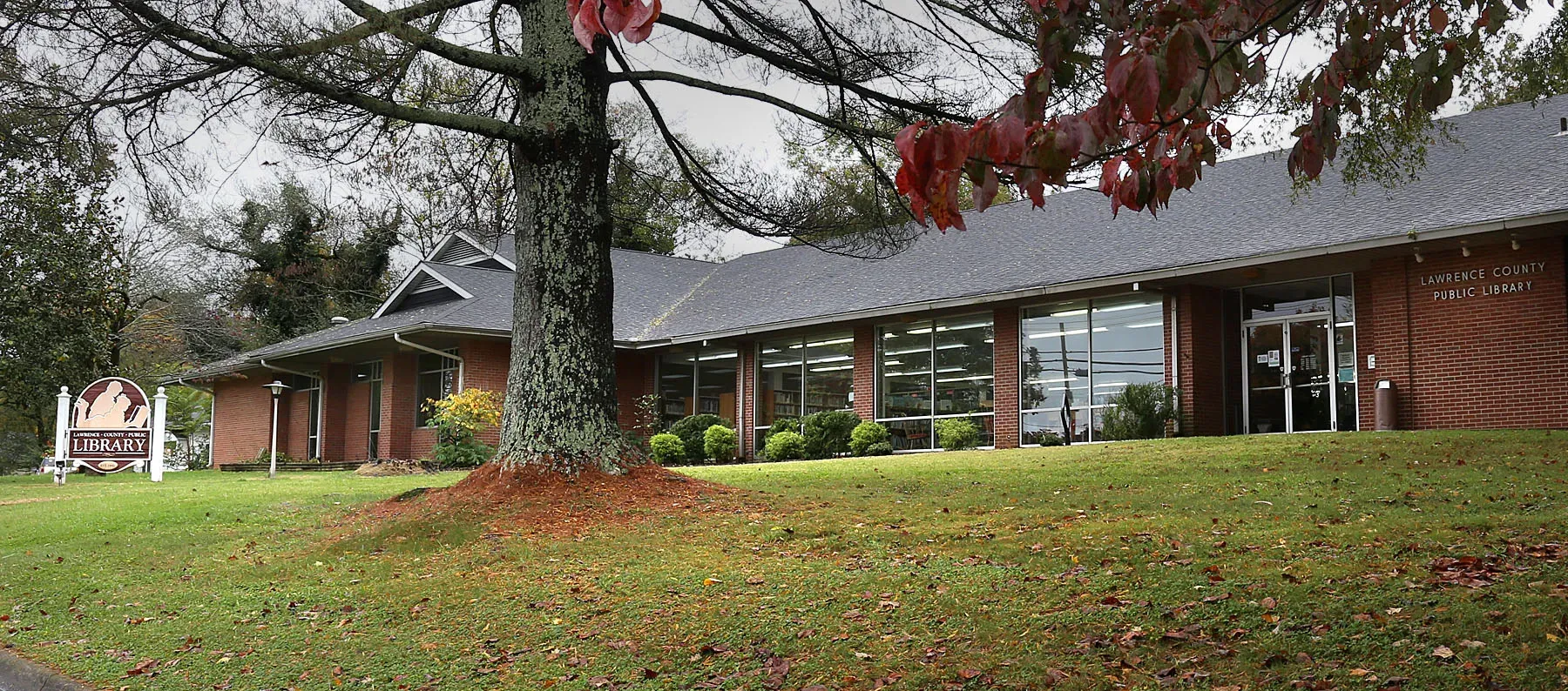 The Lawrenceburg library building on a fall day, seen across the front lawn